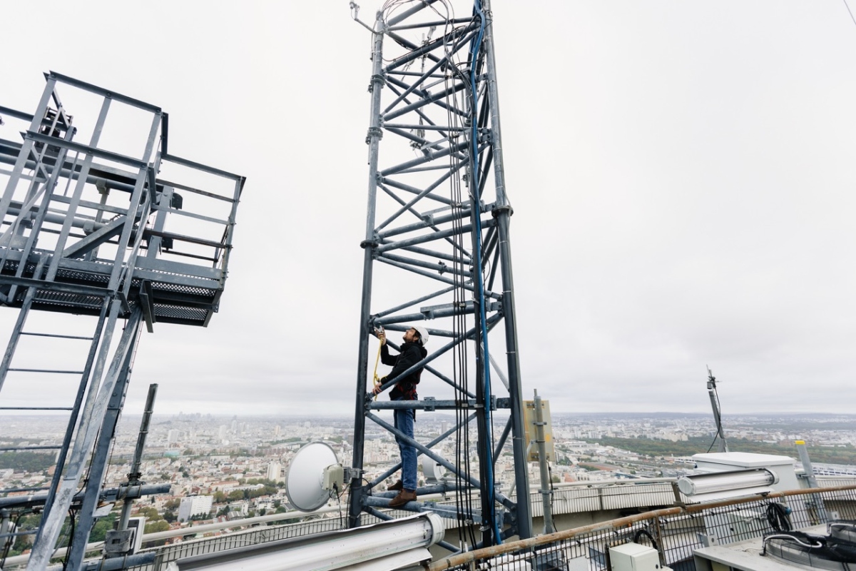 man on top of a tall building looking at instrumentation