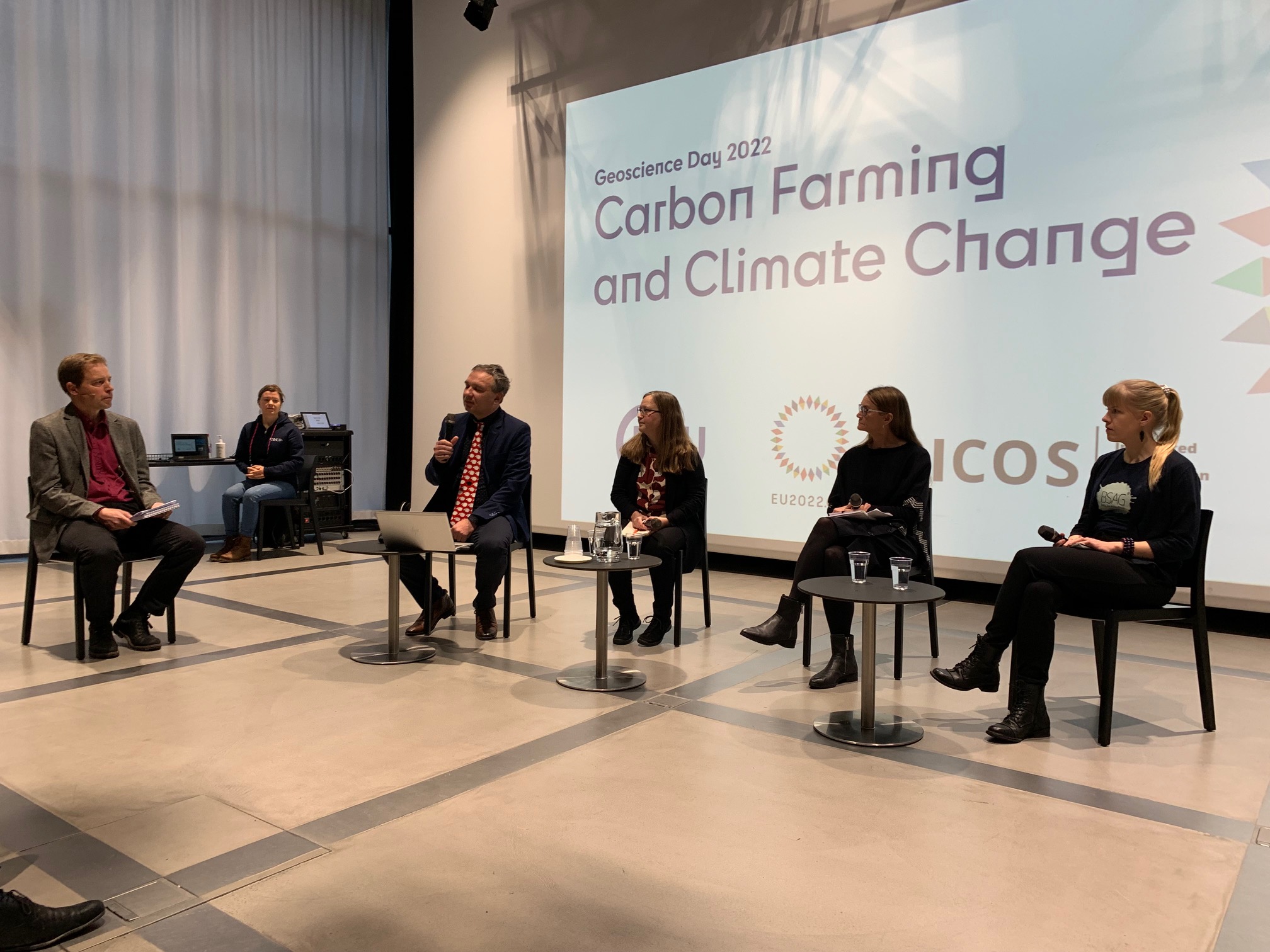 four panelists sitting side by side with a moderator on their left side