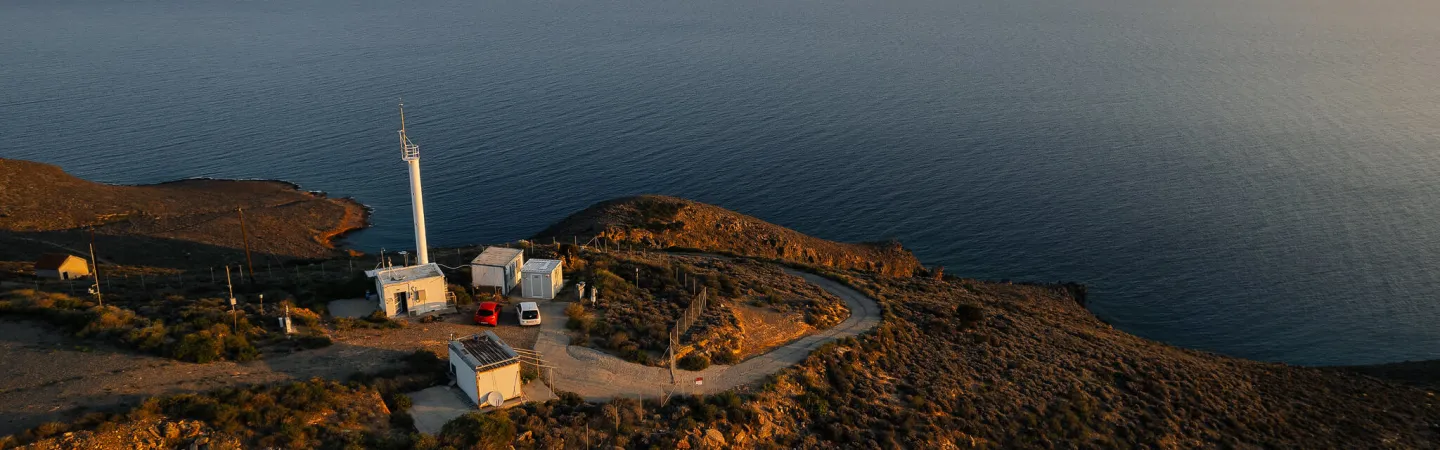 Coastal monitoring station on a rocky headland overlooking the sea at sunset