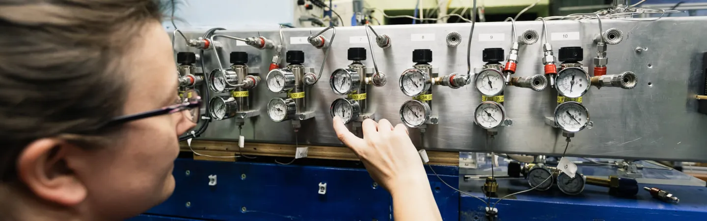 Scientist adjusting pressure gauges on laboratory equipment