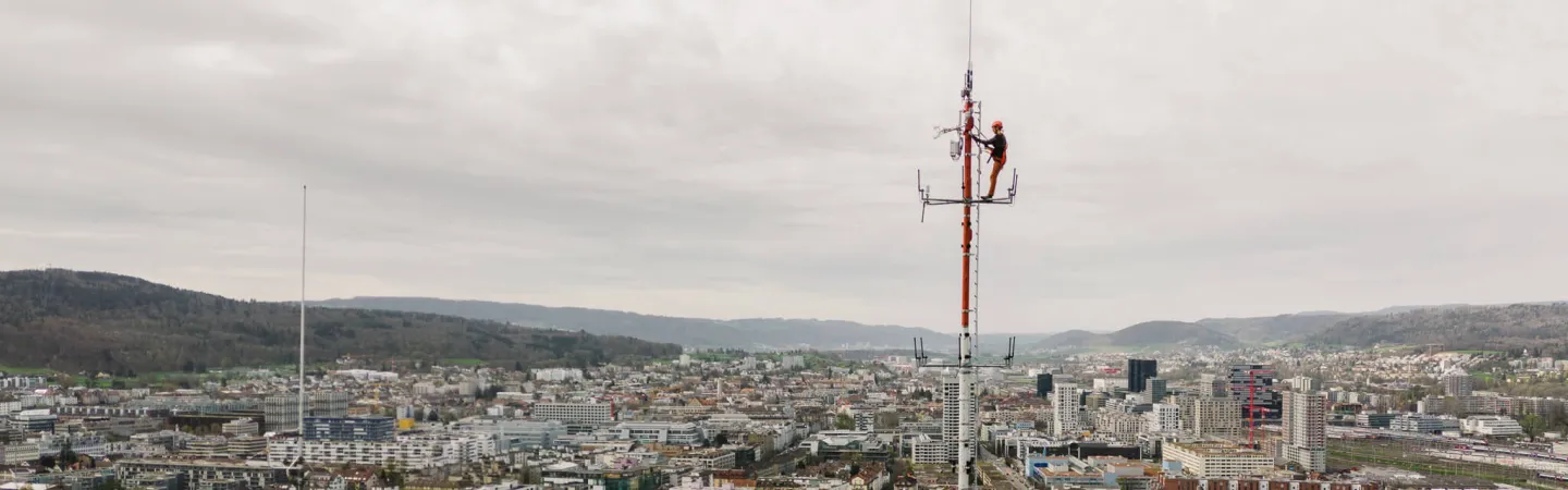 atmospheric measurement tower on top of a cityscape with a grey sky on the background