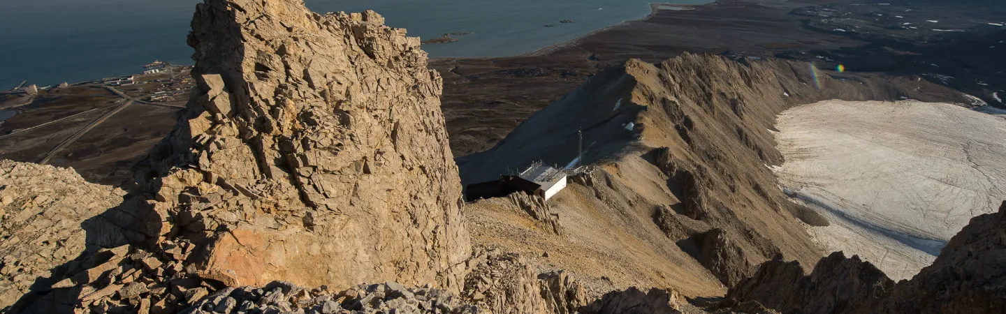 Rocky Arctic mountain ridge overlooking fjords, glaciers and distant peaks