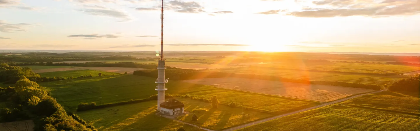 Atmospheric measurement tower over farmland at golden hour