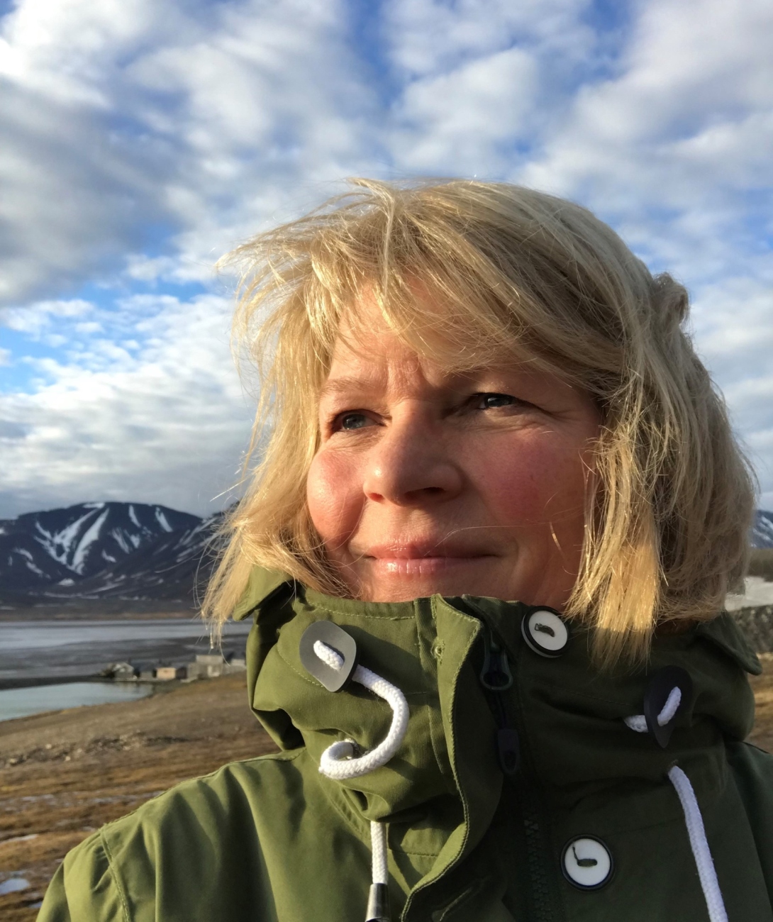 Ingunn Skjelvan looking to the left with a blue sky and mountains in the background