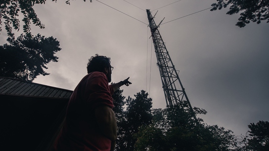 A scientist pointing at the ICOS Saclay Atmosphere station in France. 