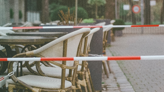 Picture of an outdoor seating area with red tape around it 