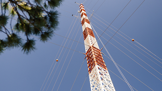 measurement tower from below with blue sky behind it 