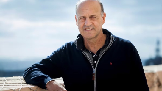 Picture of Emilio Cuevas looking at the camera with a blue sky and sunshine on the background