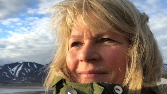 Ingunn Skjelvan looking to the left with a blue sky and mountains in the background