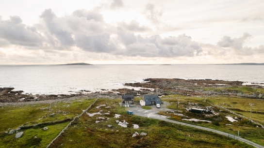 view of an atmospheric measurement station in the middle of a green landscape with a view of the open ocean on the background