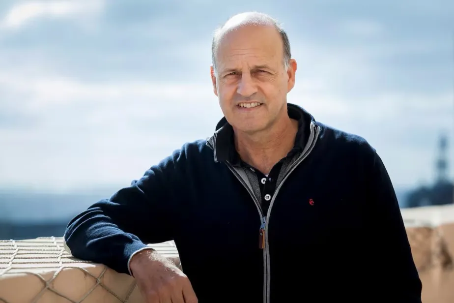 Picture of Emilio Cuevas looking at the camera with a blue sky and sunshine on the background