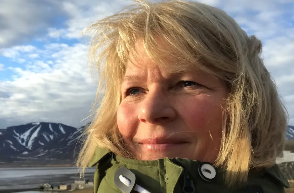 Ingunn Skjelvan looking to the left with a blue sky and mountains in the background