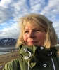 Ingunn Skjelvan looking to the left with a blue sky and mountains in the background
